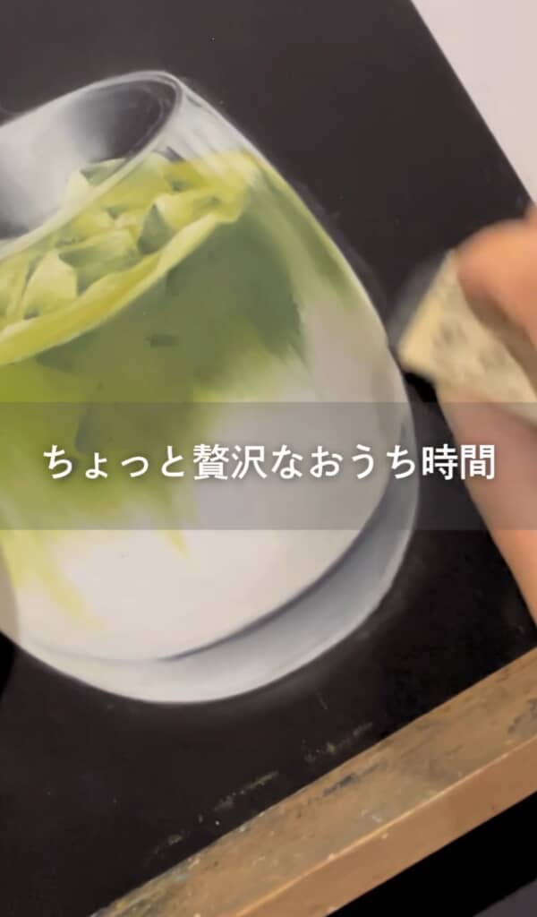 チョークアートで描かれたグラスの抹茶ラテに手で背景を塗る様子と「ちょっと贅沢なおうち時間」の文字。
