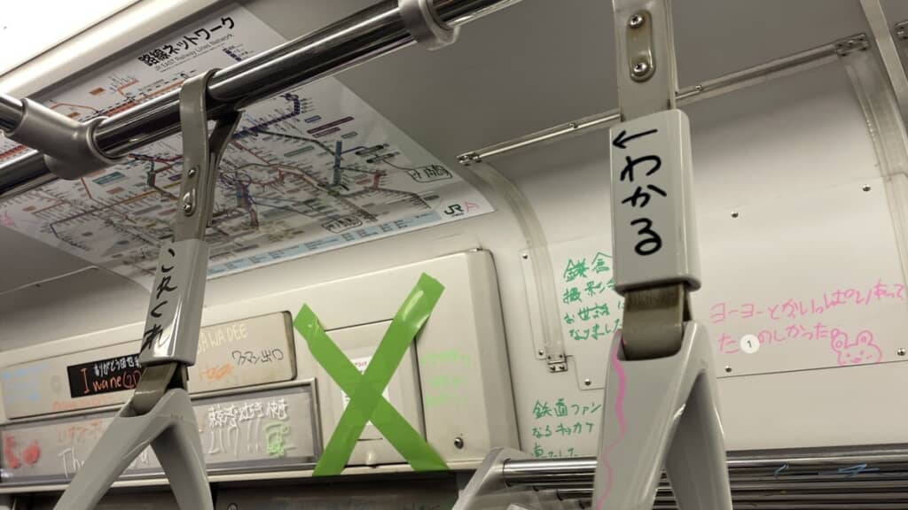 吊り革で会話している落書き