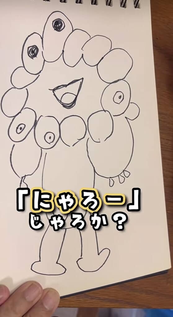 顔のまわりに目のついた楕円が輪になり、胴体と足が加わったキャラクター。