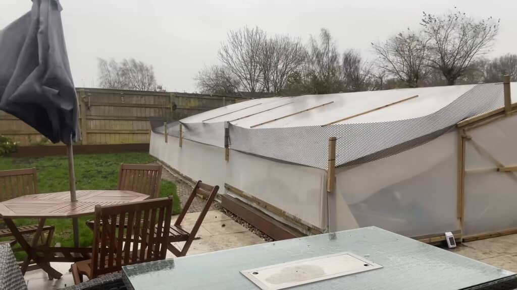 ポリトンネルで池を覆っている庭