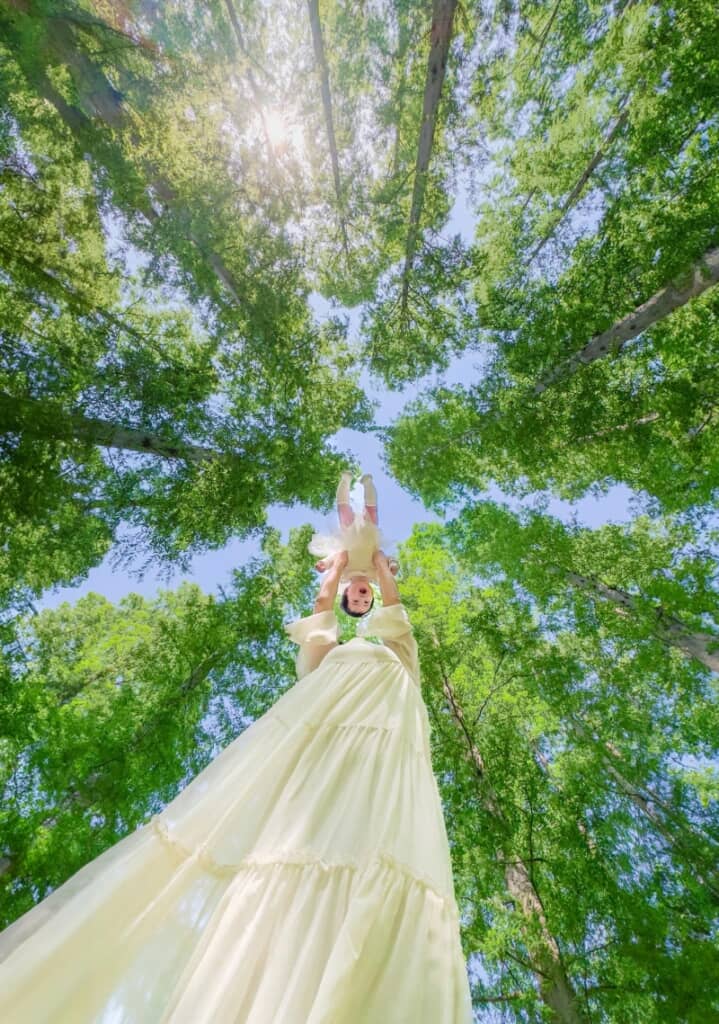 森林で生後6カ月の娘ちゃんをたかいたかいしています