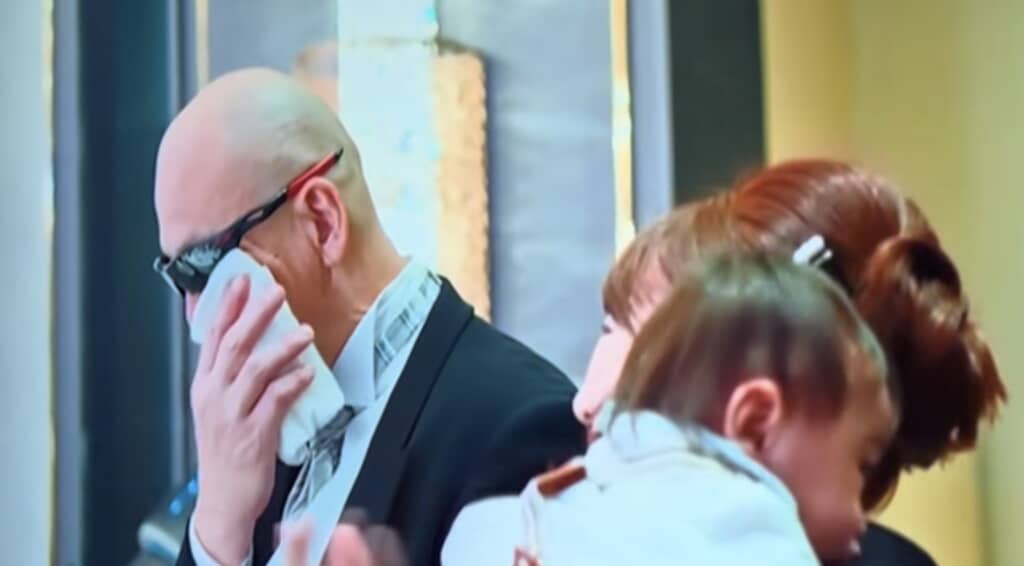 赤ちゃんを抱く母親とサングラス姿で立つ父親、結婚式会場にて。