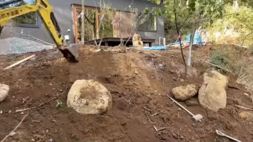 木を植えて、巨石を埋め込む様子