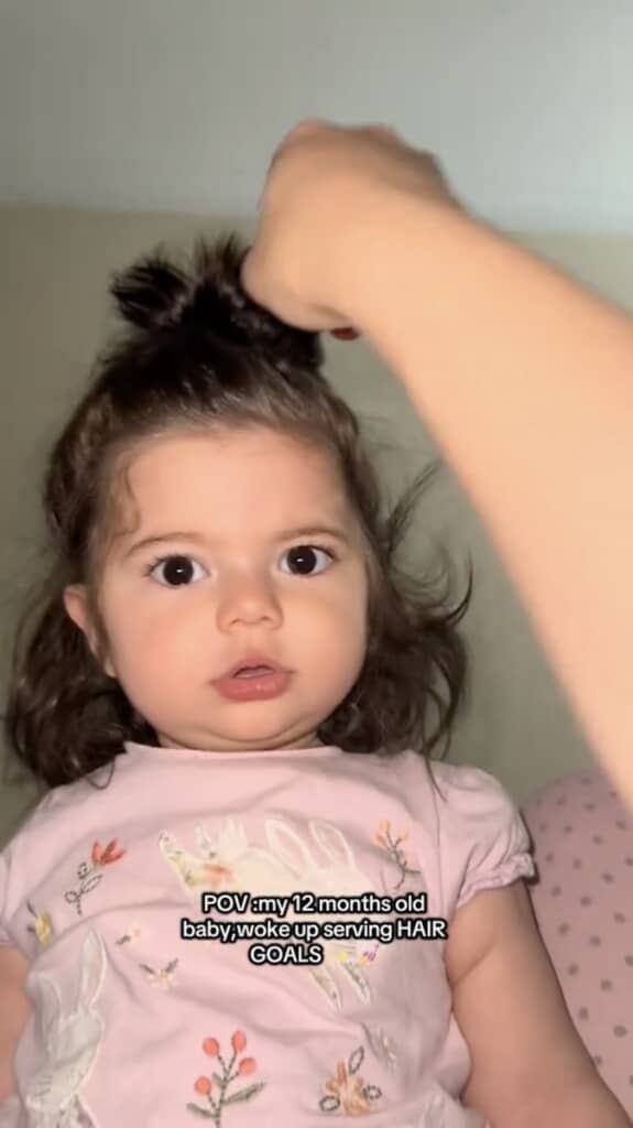 長い髪をゴムでまとめている赤ちゃん