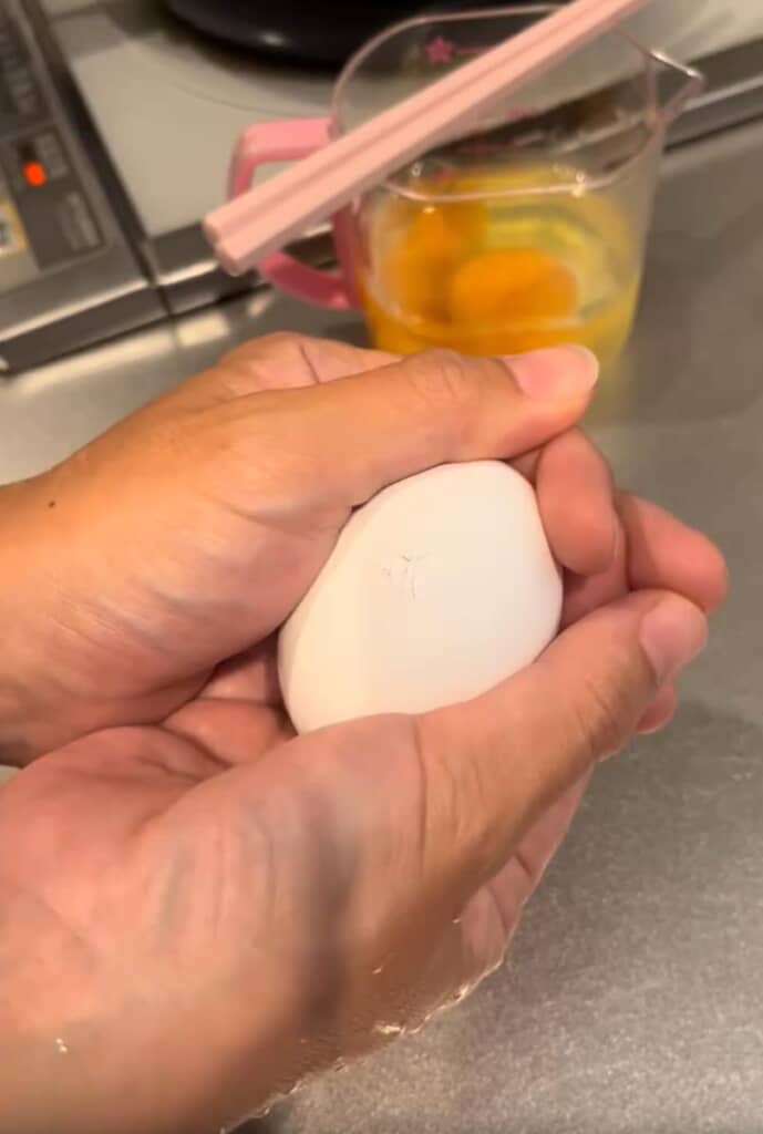 卵を大事そうに抱える妻