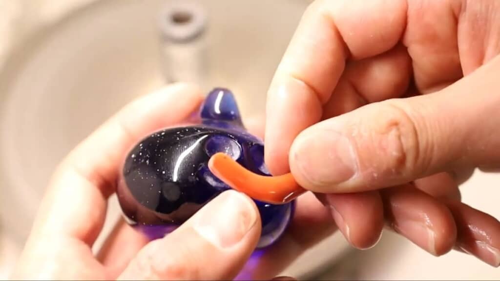 口パーツになるサンゴを削ってサイズを確認する様子