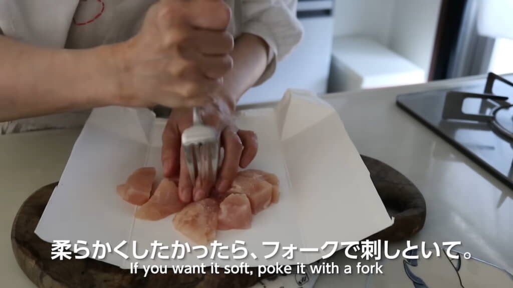 ひと口サイズにきった鶏むね肉をフォークで刺しておく
