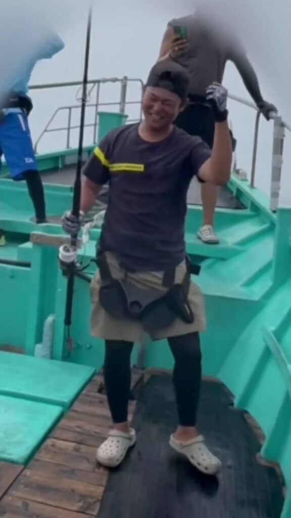 漁船に乗りマグロを釣り上げて喜ぶパパ