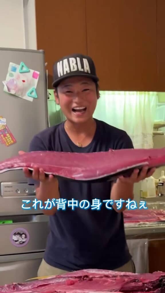 マグロの身を掲げておどけるパパ