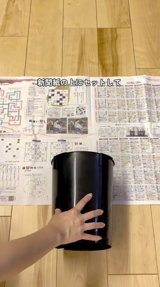 新聞紙にゴミ箱を乗せる