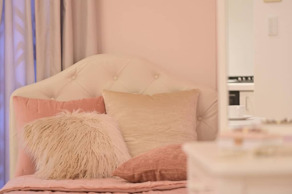 クッションとキルト調ヘッドボードのベッド