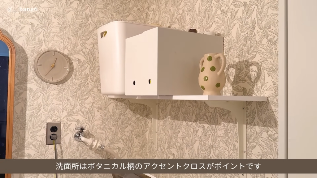 洗面所はボタニカル柄のアクセントクロスで清潔感のある印象に