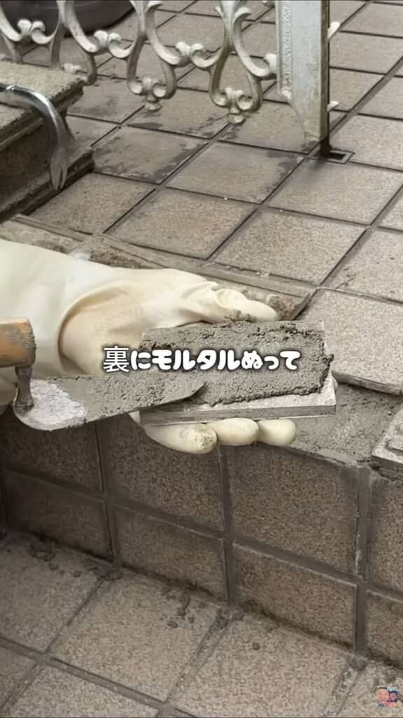 剥がしたタイルの裏にモルタルを塗る様子