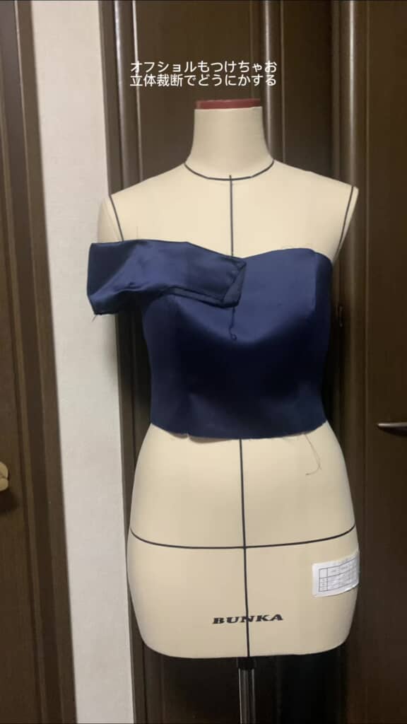 オフショルダー部分の布を当てて形を確認している