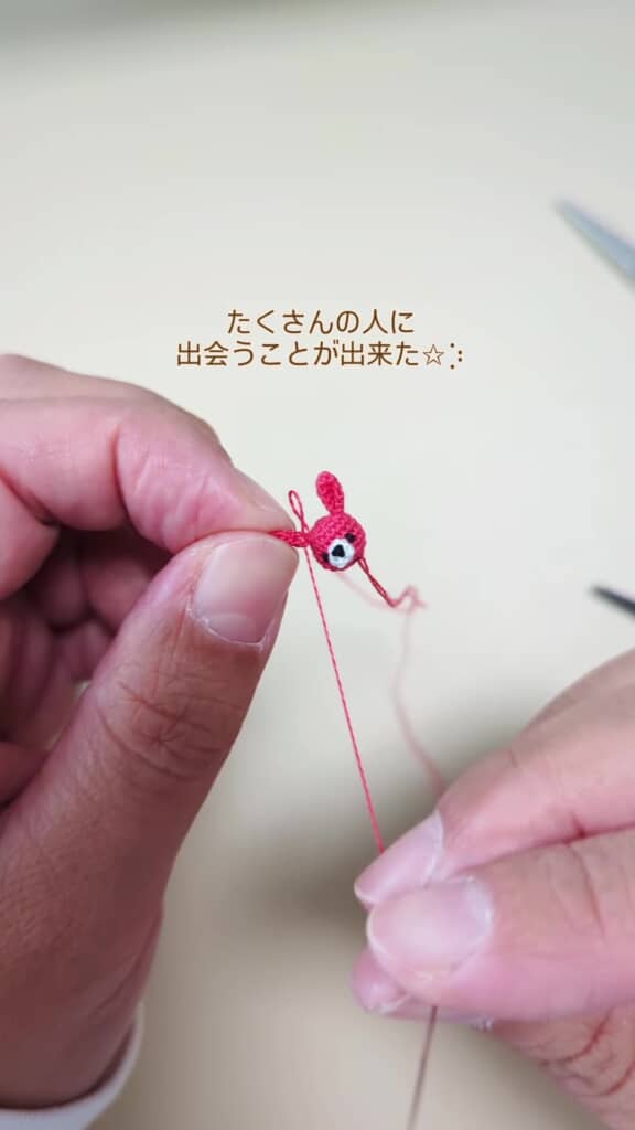 ピンクのぬいぐるみに耳を縫いつけているシーン