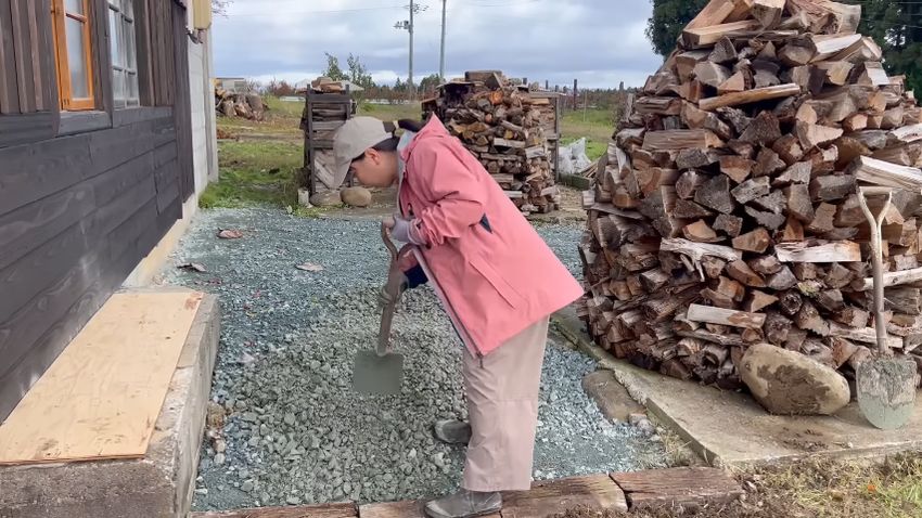 地面に敷かれた砂利をならす様子