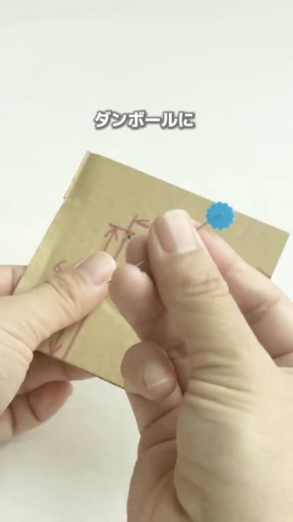 リボンと正方形を書き込んだ段ボール、まち針を用意します