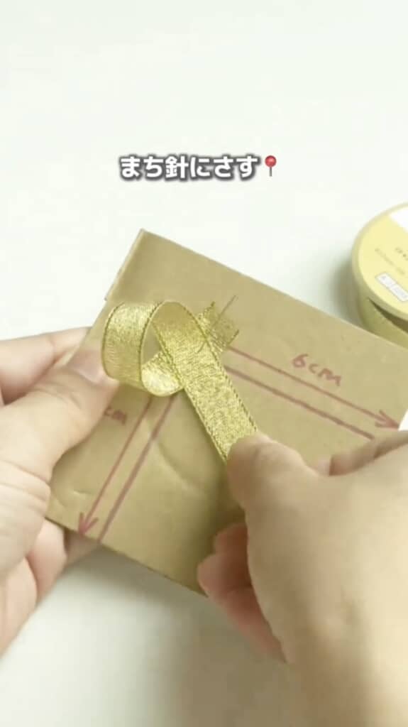 リボンをくるっと輪っかにしてまち針に刺します