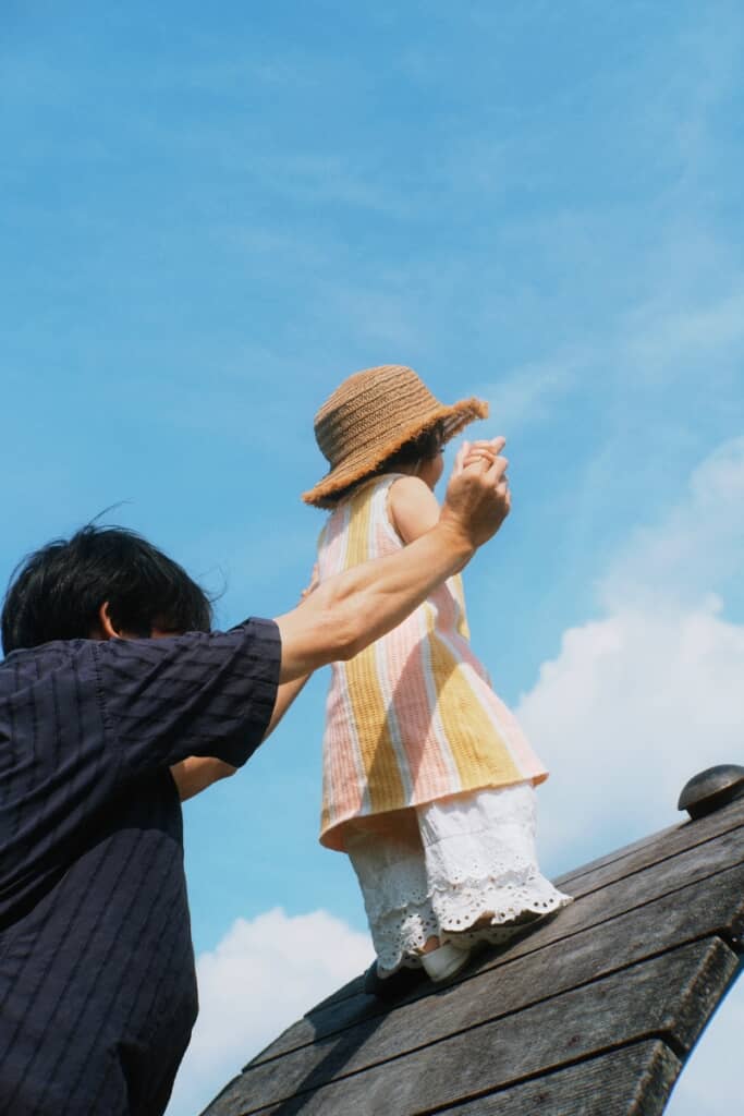 パパさんに支えられて高い場所に立つ娘ちゃん
