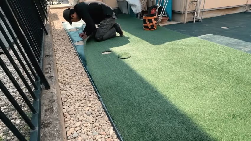 マスに合わせて人工芝を切り抜く様子