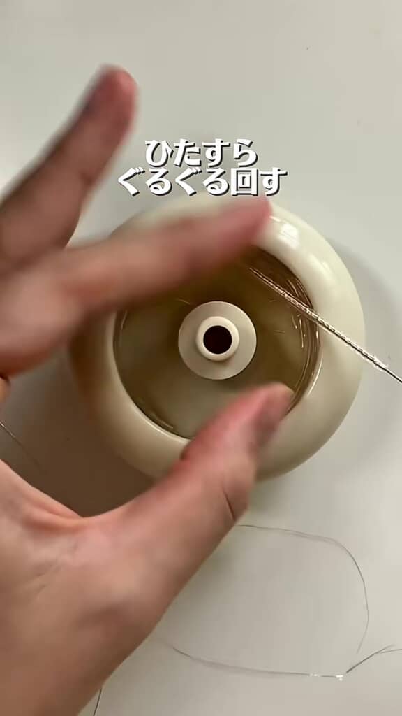 ビーズ通し機でガラスビーズを刺繍糸に通す手元