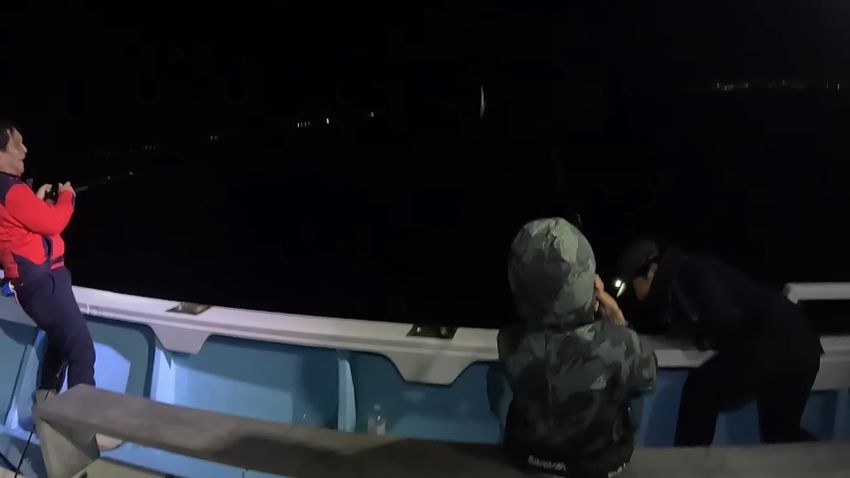 船から身を乗り出してサットウを引き上げる