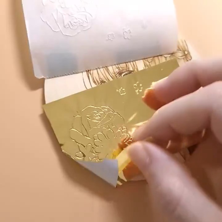 金箔を貼り、上から輪郭をなぞったウッドバーニング作品。慎重にめくると……