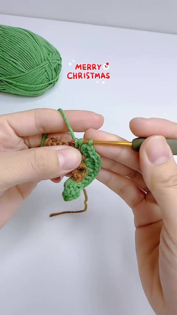 茶色と緑の毛糸でらせん状に編まれ始めたクリスマスツリーの基礎