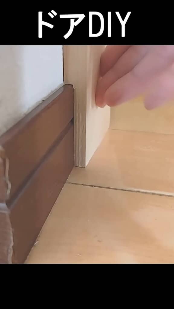 削った木材の厚みを壁に添えて確認する様子