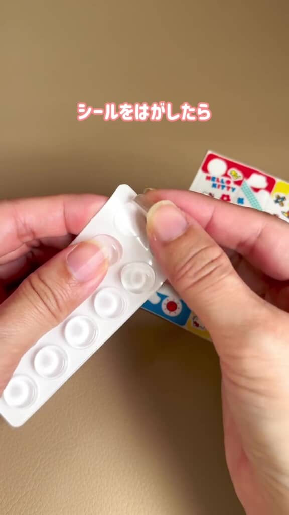 クッションシールをそっと台紙から外している場面