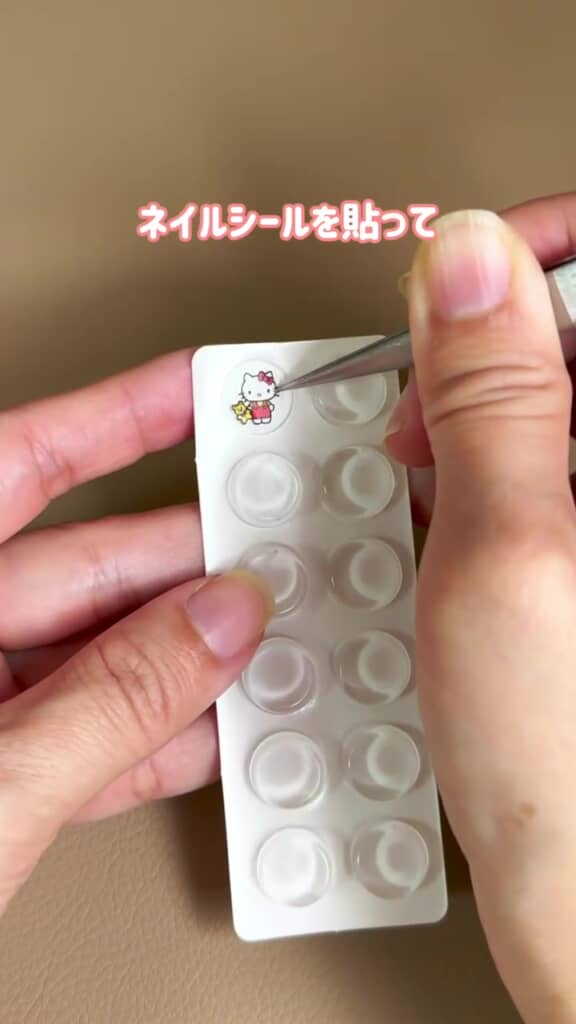 ピンセットでネイルシールを貼っている手元