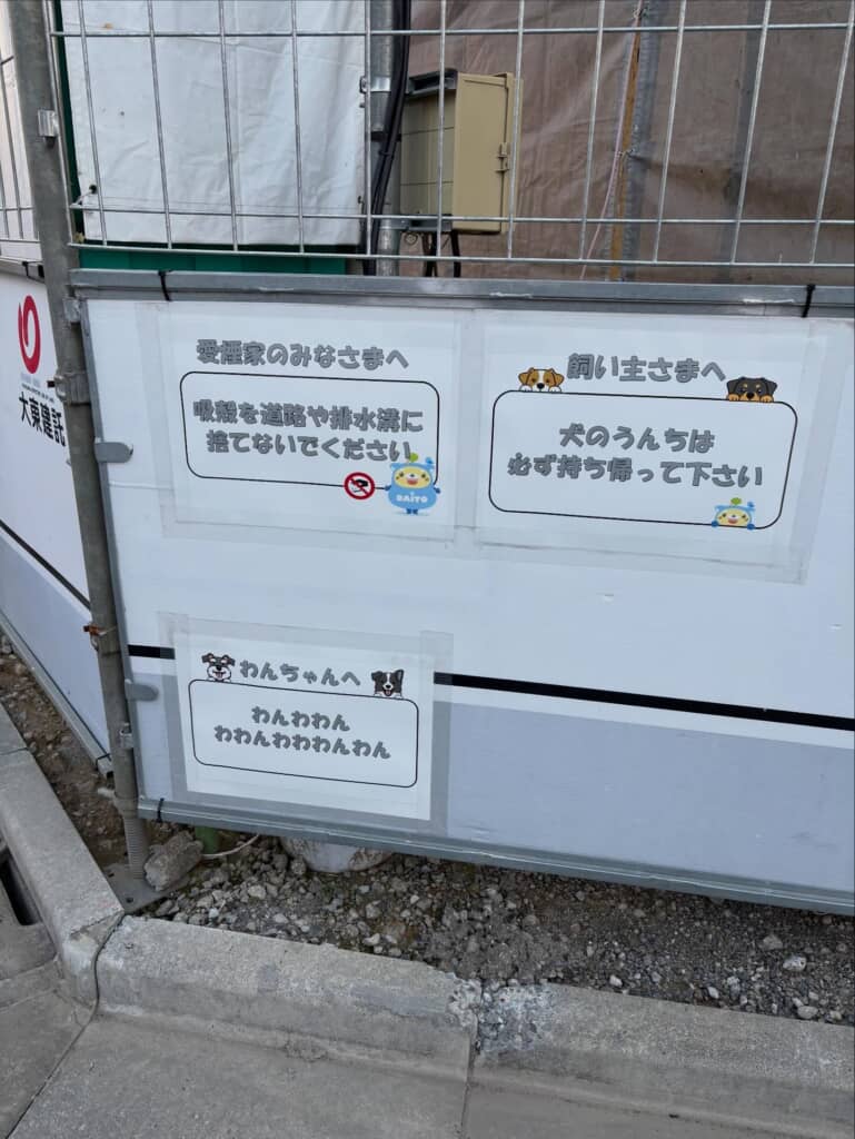 工事現場のフェンスに貼られた、愛煙家や犬の飼い主へ向けた注意書きの掲示