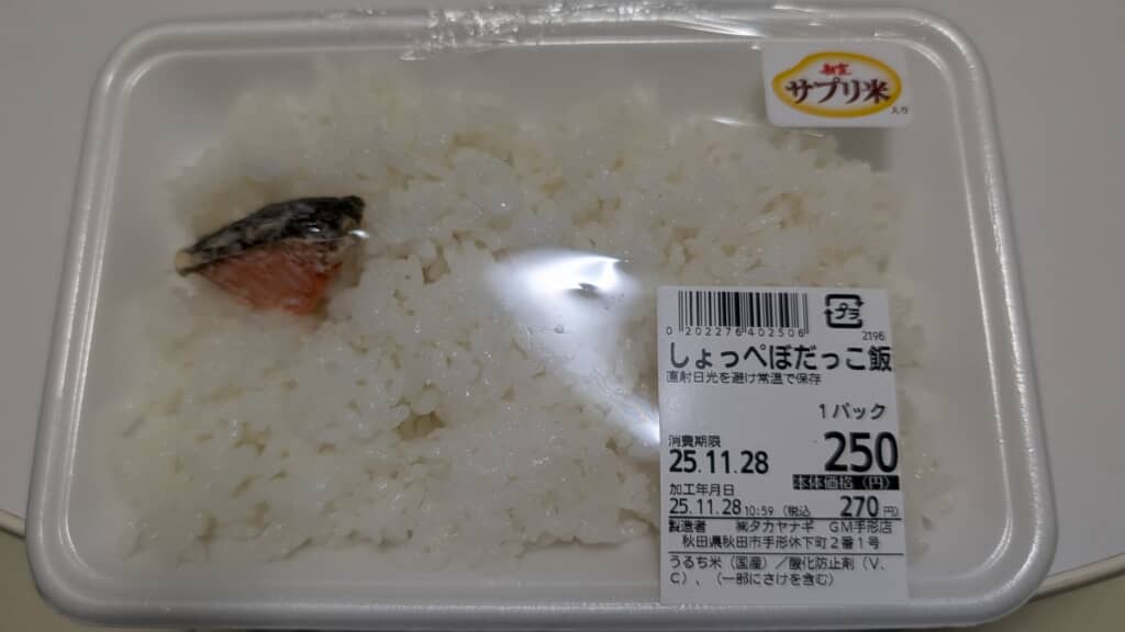「しょっぺぼだっこ飯」と書かれたラベル付きで、白飯と鮭の小片が入った弁当パック