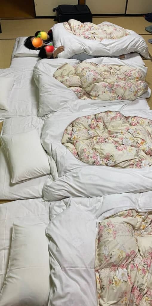 1枚の布団で眠る親子3人