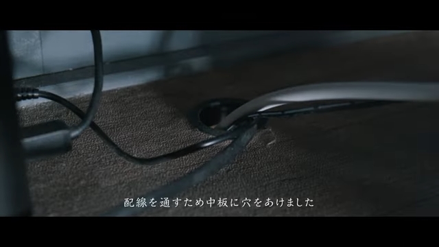 押し入れデスクの天板にあけた穴にたくさんのケーブルが通っている