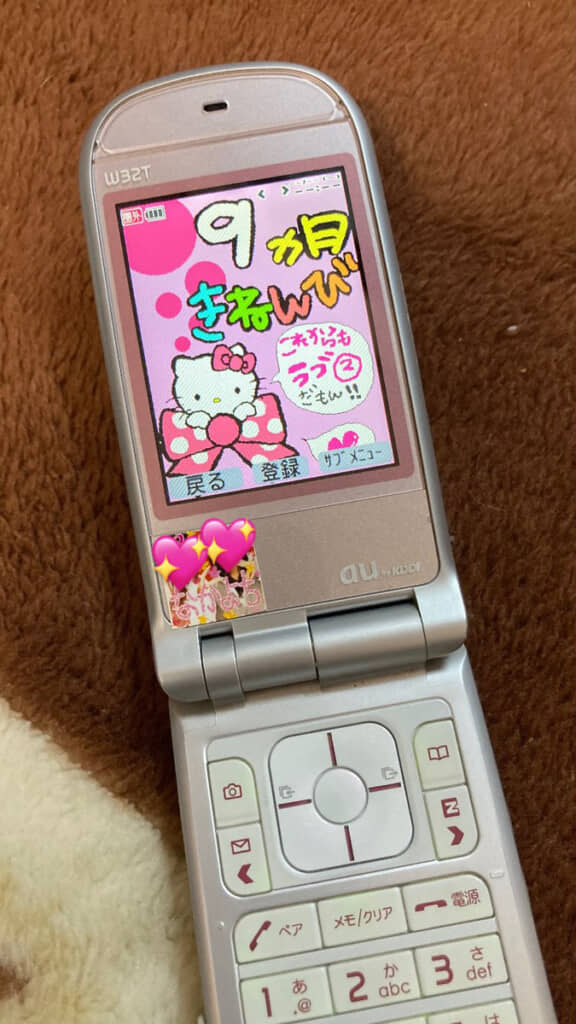 折りたたみ式のガラケーから出てきたのは、甘々にデコりまくった待受画像