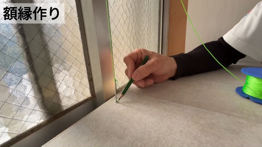 ぶら下げたネジ付きの糸でクレセント錠の位置を割り出す