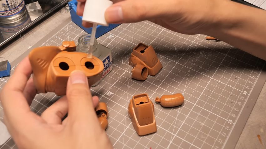 タミヤの接着剤をアッグガイの胴体に塗る様子
