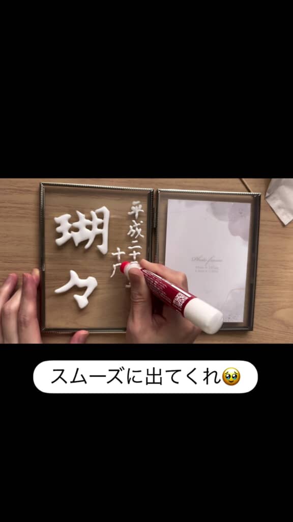 細いボンドで「平成二十三年十月十二日生」を書いている様子