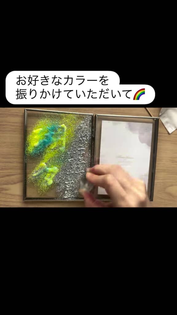 シルバーのパウダーを文字にかけている場面