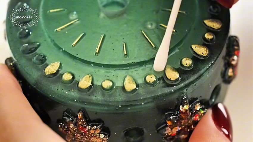 緑色の土台パーツの一部を金色に塗る様子