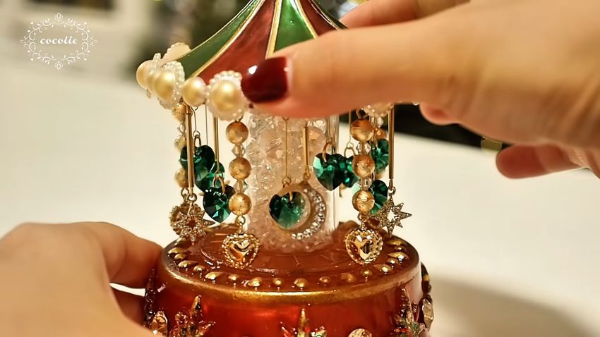 屋根から小さなパーツがたくさんつり下げられているメリーゴーラウンド型の照明