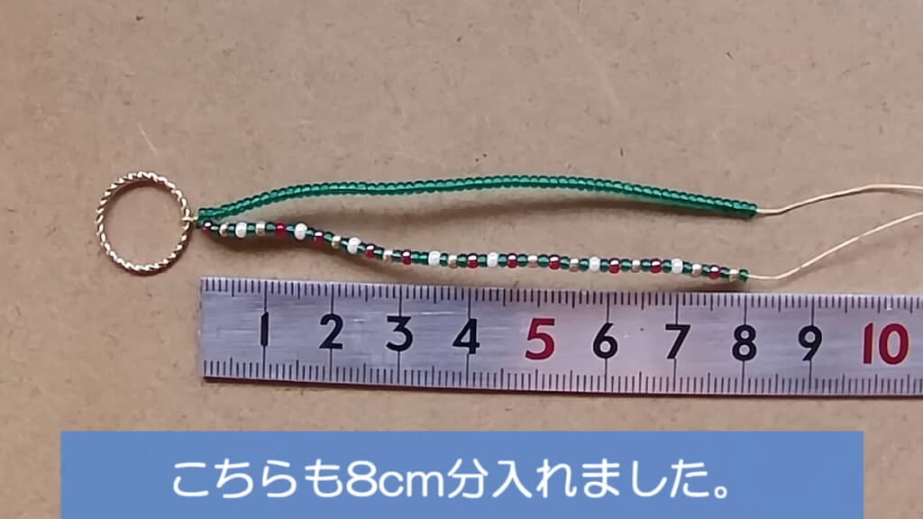 もう一方に赤・金・白・緑のビーズを8センチ分通す