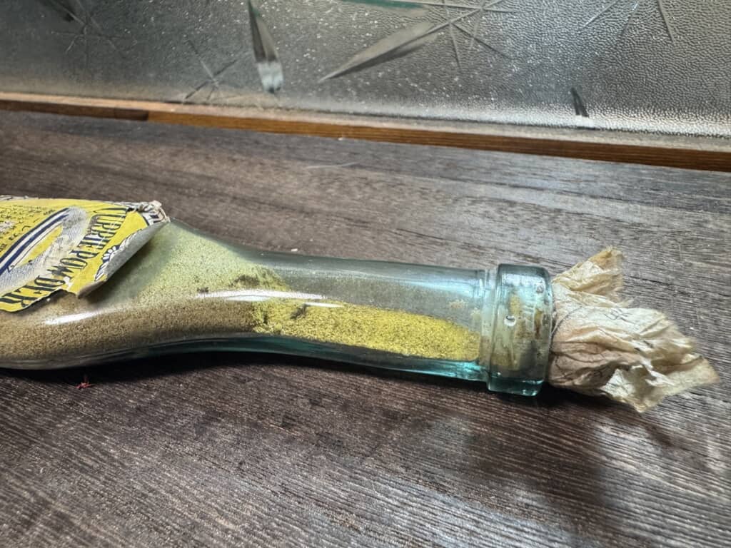 中身のカレー粉が固まったまま残っているヒドリ印カレー粉用瓶