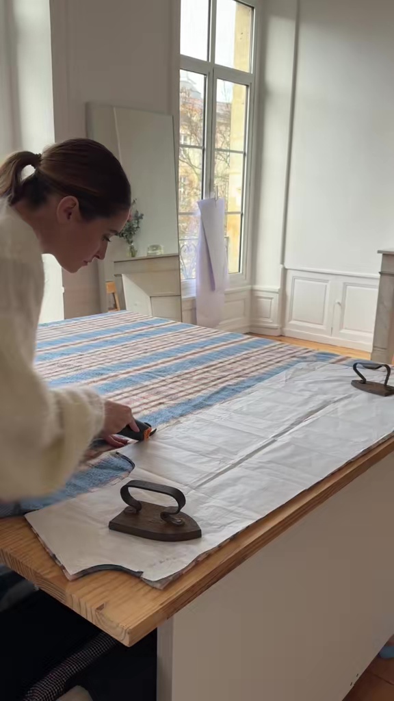 型紙を使い、ロータリーカッターで布を裁断しているシーン