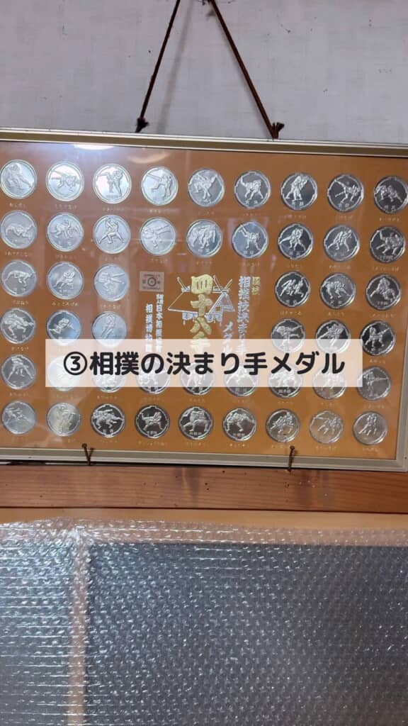 額に入れて飾ってある複数枚の相撲の決まり手メダル