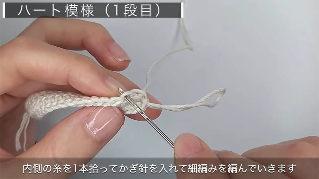 ホワイトとブラウンの糸でハート模様を編んでいきます