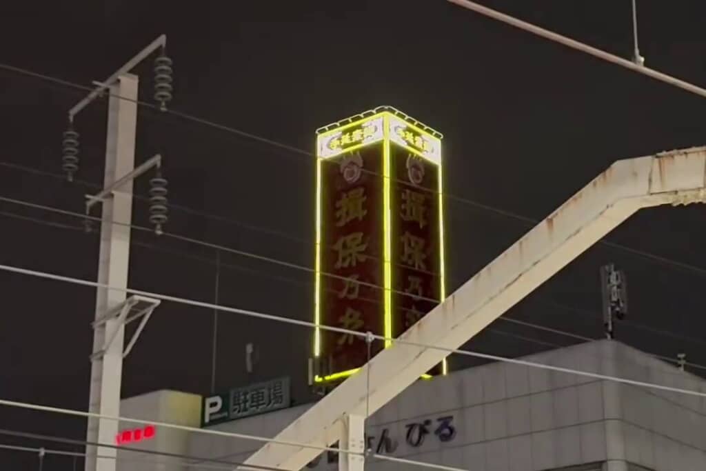 枠部分が黄色く鮮やかに光った赤茶色の看板