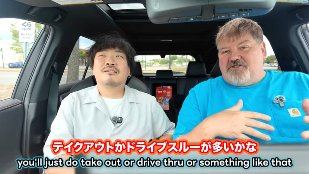 車内で2人の男性がテイクアウトやドライブスルーについて話している。