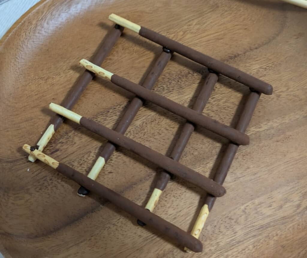 棒状のお菓子を格子状に組んで作った家の土台